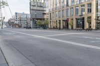 a person is riding his bike down an empty street, near buildings on the opposite side