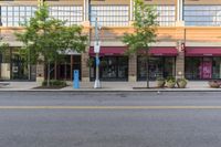 an empty city street and two buildings with some signs above them to show customers the number of customers, including one car