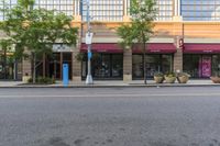 an empty city street and two buildings with some signs above them to show customers the number of customers, including one car