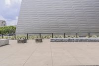 a skateboarder in front of a large silver building that has been designed to resemble a cube
