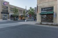 an empty street in a downtown area with buildings on the other side and signs around