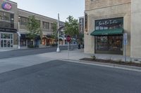 an empty street in a downtown area with buildings on the other side and signs around