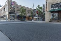 an empty street in a downtown area with buildings on the other side and signs around