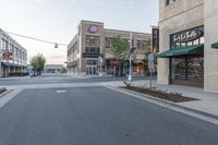 a wide empty street is shown in front of stores, and businesses in the background