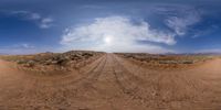 a street view looking up the side of a dirt road in desert country with sky background