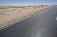 a person on a motorcycle rides down some road in the desert as it goes toward the camera