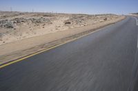 a person on a motorcycle rides down some road in the desert as it goes toward the camera