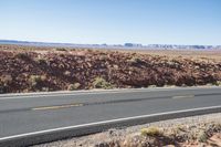 Desert Highway: Asphalt Road with Red Rock Surroundings