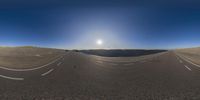 a desert with a small highway going right in front of the sun and a truck driving down the road