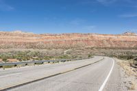 a curve of a highway with the mountains in the distance at the background that is dry and rocky
