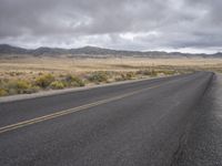 there is a small yellow sign on the side of the road near a large desert area