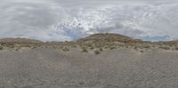 a view of a desert under clouds in the background with the word no parking written below