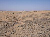 a truck on a dirt road in the desert with rocks and stones on the ground