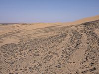 a truck on a dirt road in the desert with rocks and stones on the ground