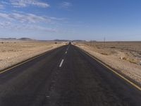 an empty street that is connected to a dry area near the horizon in the desert