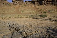 a dog is standing on rocks in the desert outside of a rocky canyon area with some brown and tan rocks