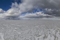 a view from inside a boat in the middle of the ocean with large clouds above