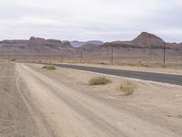 the empty road leads into the middle of the desert landscape in the distance, near a distant mountain range