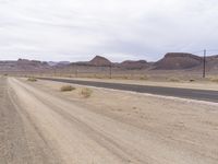 the empty road leads into the middle of the desert landscape in the distance, near a distant mountain range