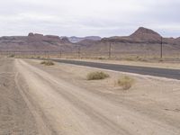 the empty road leads into the middle of the desert landscape in the distance, near a distant mountain range