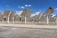 a row of solar panels on the ground of a solar park in the desert setting