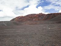 a person riding their horse on a very barren desert land area as clouds hove in