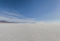 a barren area with mountains in the background and no clouds in the sky, with only one person visible