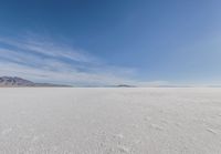 a barren area with mountains in the background and no clouds in the sky, with only one person visible