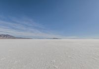 a barren area with mountains in the background and no clouds in the sky, with only one person visible