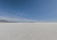 a barren area with mountains in the background and no clouds in the sky, with only one person visible