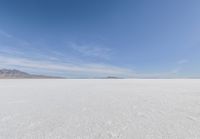 a barren area with mountains in the background and no clouds in the sky, with only one person visible