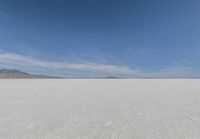 a barren area with mountains in the background and no clouds in the sky, with only one person visible