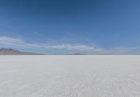 a barren area with mountains in the background and no clouds in the sky, with only one person visible