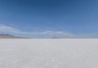 a barren area with mountains in the background and no clouds in the sky, with only one person visible