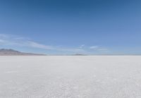 a barren area with mountains in the background and no clouds in the sky, with only one person visible