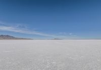 a barren area with mountains in the background and no clouds in the sky, with only one person visible