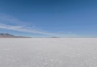 a barren area with mountains in the background and no clouds in the sky, with only one person visible