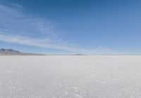 a barren area with mountains in the background and no clouds in the sky, with only one person visible