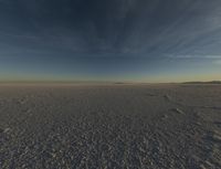 the sun is rising over a plain of barren land and hills on both sides of the horizon