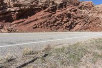 the red rocks and mountain are part of the landscape, in this shot there is a white road sign