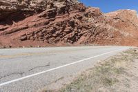 the red rocks and mountain are part of the landscape, in this shot there is a white road sign