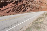 the red rocks and mountain are part of the landscape, in this shot there is a white road sign