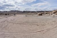 a stop sign in the middle of a rocky desert area with mountain range in the distance