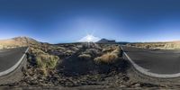 the road from a fisheye lens is narrow and winding through the desert land near the sun