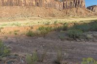 a view of a mountain and grassy area from an overlook looking up at something out in the distance