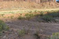 a view of a mountain and grassy area from an overlook looking up at something out in the distance