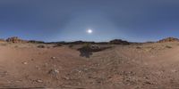 a person stands in the middle of some dirt in a desert area, with an island and sky beyond