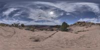 a 360 view of the desert looking back towards the sky with a full moon in it