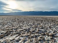 an empty landscape with lots of dirt in the foreground, and mountains on the right