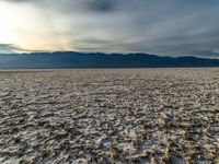 an empty landscape with lots of dirt in the foreground, and mountains on the right